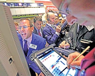 Specialist Michael Pistillo, left, calls out prices as he works at his post on the floor of the New York Stock Exchange Wednesday, July 27, 2011. (AP Photo/Richard Drew)