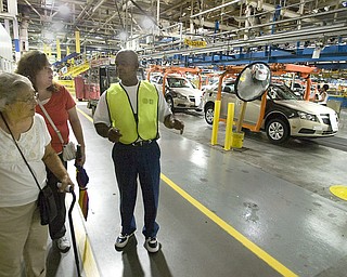 General Motors Co. Lordstown worker Todd Burns shows Irma Locke, left, and her daughter Nancy Locke, of North Jackson, the assembly line during GM’s open house Thursday. The 9,000 who toured went on 30-minute tours through the east and west complexes.