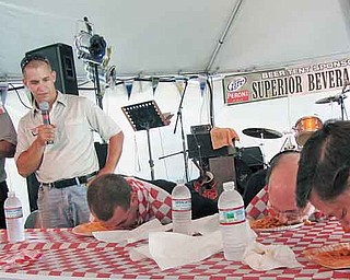 Duke Girardi of Boardman, far left, stands up as he finishes eating around a pound of rigatoni at the Greater Youngstown Italian Fest on Saturday afternoon. Girardi finished first in the pasta-eating contest, which he has entered in each of the last 11 years. The emcee, second from left, was Todd DeMain, and the other contestants are, seated from left, Michael DeLucia III of Green near Akron, MichaelDeLucia II of Green and Scott Cross of Columbiana.