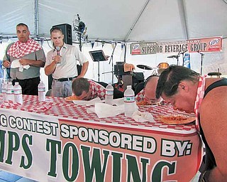 Duke Girardi of Boardman, far left, stands up as he finishes eating around a pound of rigatoni at the Greater Youngstown Italian Fest on Saturday afternoon. Girardi finished first in the pasta-eating contest, which he has entered in each of the last 11 years. The emcee, second from left, was Todd DeMain, and the other contestants are, seated from left, Michael DeLucia III of Green near Akron, MichaelDeLucia II of Green and Scott Cross of Columbiana.