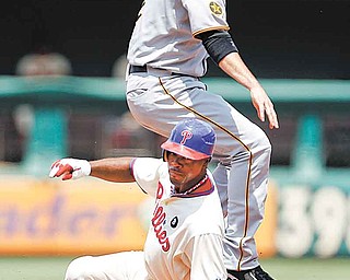 Pittsburgh Pirates shortstop Brandon Wood, top, leaps to avoid Philadelphia Phillies’ Jimmy Rollins after forcing him out at second base on a fielder’s choice by Shane Victorino in the fi rst inning of a baseball game Sunday in Philadelphia. Victorino was safe at fi rst. The Phillies won 6-5 in 10 innings.