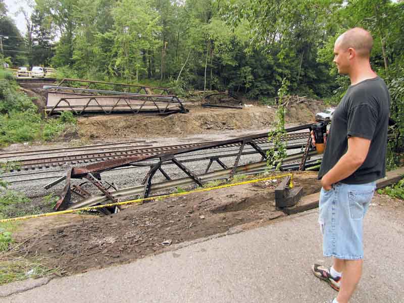 Jason Crisp of Niles stands near the edge of the former 5th Street bridge over the CSX train tracks on the south side of Niles. The  bridge, which carried cars over the tracks, was removed Saturday  after it was damaged by a train that derailed. 