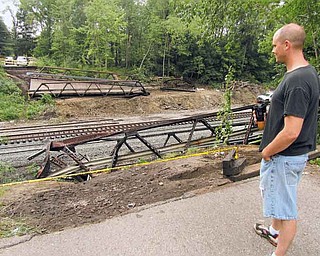 Jason Crisp of Niles stands near the edge of the former 5th Street bridge over the CSX train tracks on the south side of Niles. The  bridge, which carried cars over the tracks, was removed Saturday  after it was damaged by a train that derailed. 