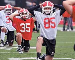 Jamaine Cook (35), stretches during the first practice of Youngstown State’s spring football practice at
Stambaugh Stadium. Cook, sophomore Nick Liste and offensive lineman Dan Radakovich, were named to the Missouri Valley Football Conference preseason all-conference team Monday.
