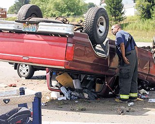 Firefighter Gary Howell of the Youngstown Fire Department inspects the scene of an accident. Three people were hospitalized after a three-car accident on Interstate 680 northbound about 10:30 a.m. Tuesday. A woman was driving with an infant southbound near the state Route 711 ramp when she lost control of her red pickup truck, hit the median and flipped the truck, hitting a vehicle headed northbound. The northbound SUV was then lightly hit from behind by another truck. The woman, the baby and the woman driving the northbound vehicle were all taken to St. Elizabeth Health Center in Youngstown. Police said everyone was expected to fully recover.