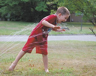 Landon Malmfeldt, 4, has a blast playing in the spray at his home in Boardman. Photo submitted by Ronnie Malmfeldt.