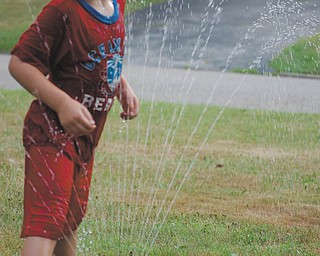 Landon Malmfeldt, 4, has a blast playing in the spray at his home in Boardman. Photo submitted by Ronnie Malmfeldt.