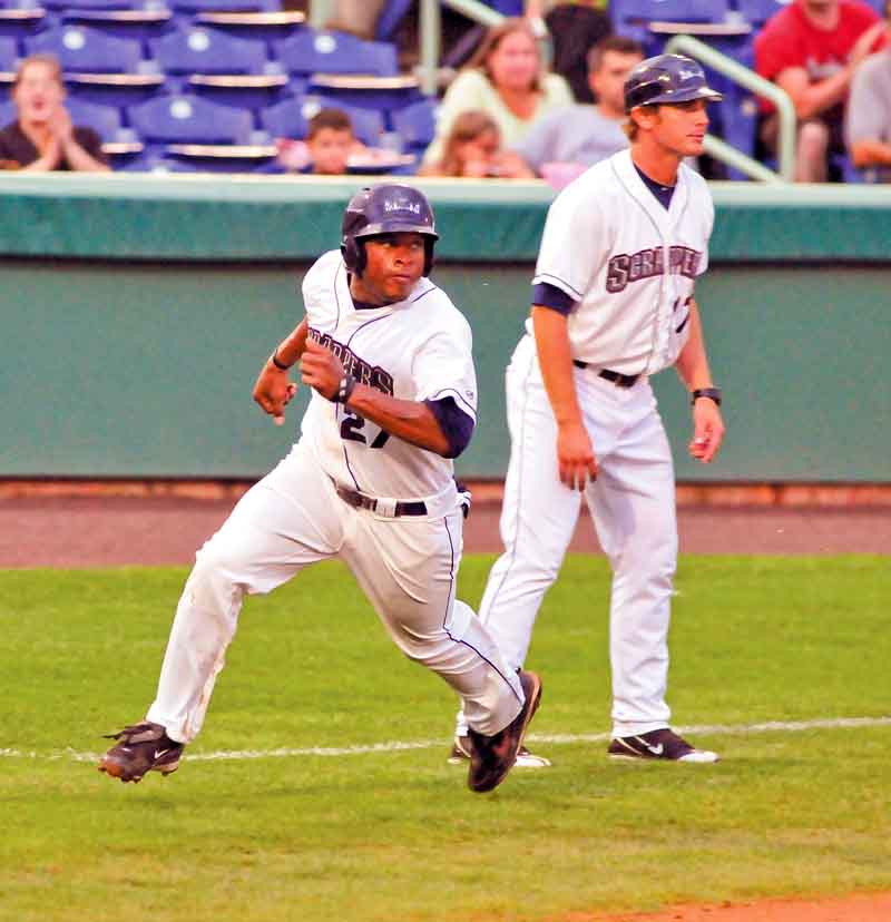 Scrappers baserunner Bryson Myles rounds third base to score as third base coach Dave Wallace watches at Eastwood Field.
