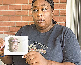 Rhonda Woodall of Youngstown shows a picture of her son, Braylen Collins, 17, who was shot and killed on the city’s South Side last week. Woodall also had to grieve over the loss of Collins’ father, who was shot and killed a month before Braylen was born in 1994.