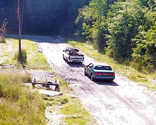 One of Youngstown’s illegal-dumping cameras shows a pickup and a car traveling on the East Side. The truck is carrying wood that the camera later would show being dumped on the side of the street.