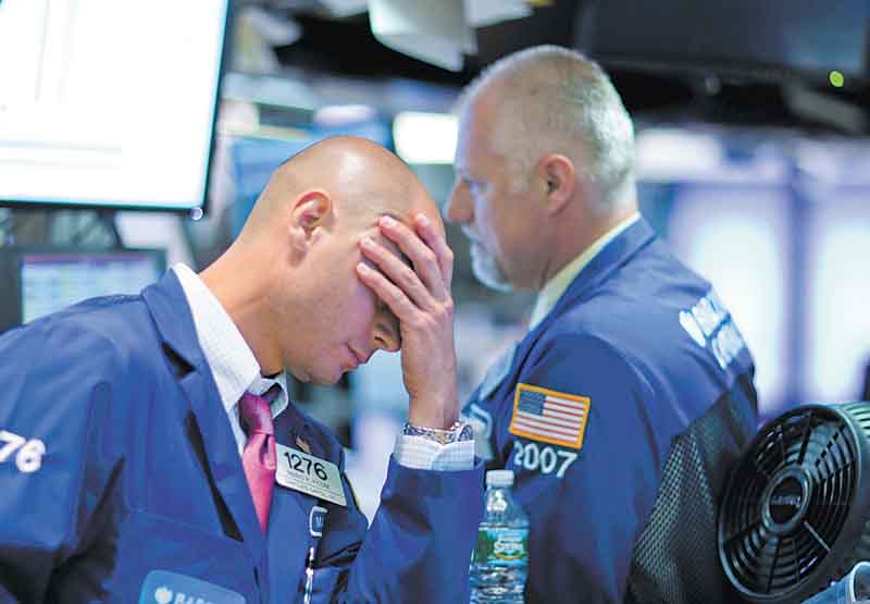 Traders show their frustration as they work on the floor of the New York Stock Exchange on Thursday. The Dow dropped 4.3 percent to close at 11383.68.