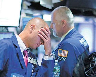 Traders show their frustration as they work on the floor of the New York Stock Exchange on Thursday. The Dow dropped 4.3 percent to close at 11383.68.
