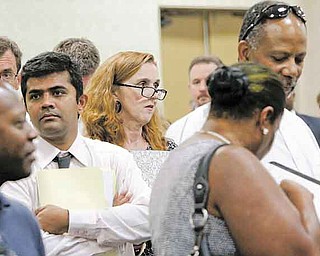 In this July 13, 2011 photo, attendees stand in lines that weave throughout a room filled with recruiting booths during a National Career Fairs job fair, in Dallas. The number of people seeking unemployment benefits dipped last week, a sign the job market may be improving slowly.(AP Photo/Tony Gutierrez)