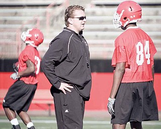 Youngstown State football coach Eric Wolford, left, talks with wide receiver Jelani Berassa during 2010 spring practice. The Penguins begin practice today for the 2011 season opener at Michigan State on Sept. 2.