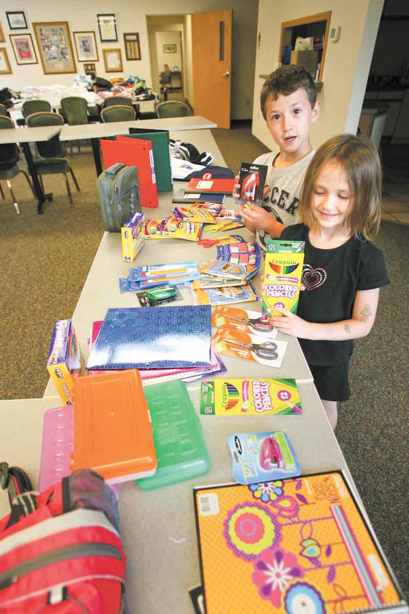 Cody Koellner, 10, and his sister, Colleen Koellner, 6, look over items they will be able to shop for at the Beautitude HouseÕs Òmock storeÓ at its administrative offices at 238 Tod Lane on the campus of St. Edward parish in Youngstown or at its location at 1370 Tod Ave. NW in Warren on Aug. 12. The deadline for donations is Wednesday..