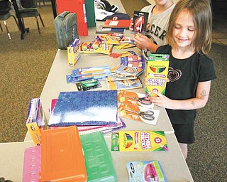 Cody Koellner, 10, and his sister, Colleen Koellner, 6, look over items they will be able to shop for at the Beautitude HouseÕs Òmock storeÓ at its administrative offices at 238 Tod Lane on the campus of St. Edward parish in Youngstown or at its location at 1370 Tod Ave. NW in Warren on Aug. 12. The deadline for donations is Wednesday..