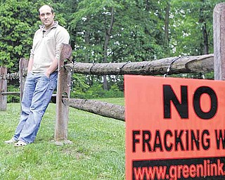 In this May 27, 2011 photo, T.J. Turner stands in his yard in Yellow Springs, Ohio, near a  sign protesting the practice of fracking, a process used to extract oil or natural gas from hard rock formations. Turner is a local resident who was approached by a salesman for an energy exploration company to lease rights for drilling on his property. (AP Photo/Jay LaPrete)