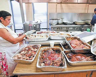 Maria Rodriquez of Youngstown separates pork from the bones in the kitchen at the 48th annual St. Rose of Lima Church Festival, Tenney Avenue, Campbell. The festival features Spanish food as a main attraction and continues from 5 to 11 p.m. today.