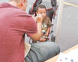 Jose Esparra of Campbell paints a Spider-Man face on Jayden Hartsfield, 2, of Liberty, late Saturday afternoon at the church festival in Campbell.