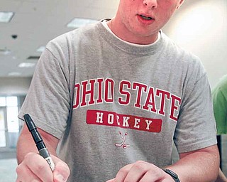 Wiley Collett of Troy, Ohio, a Youngstown State University sophomore, shows how he prints and 
cursively writes his name.