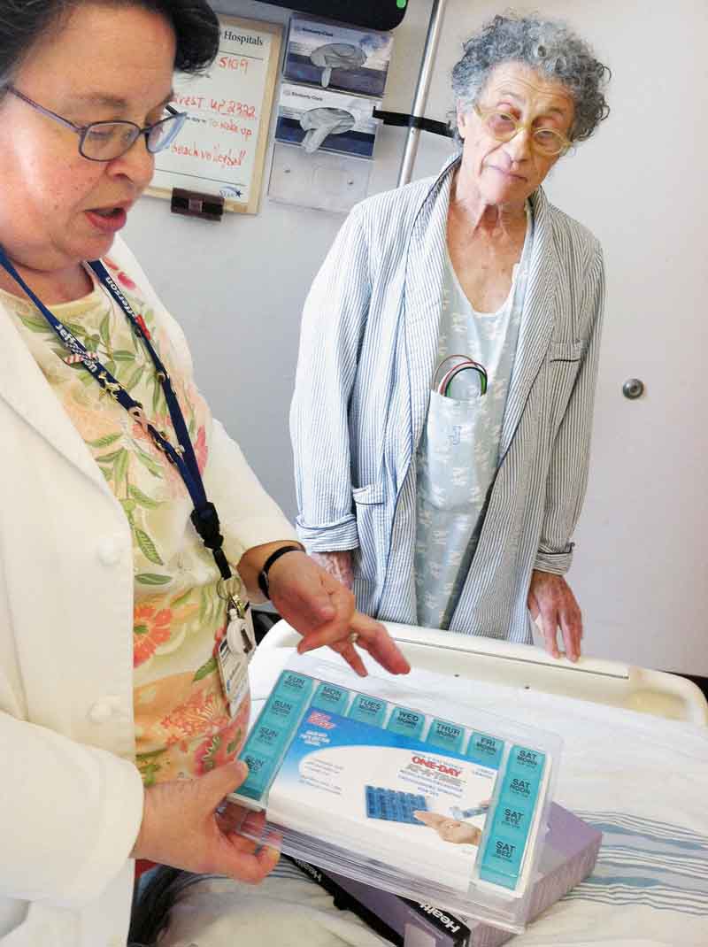 Pharmacist Joanne Heil, left, of Thomas Jefferson University Hospital, shows patient Pierre Trombert a pillbox that will help him organize his medicines at home so he won't get sick and have to come back to hospital. (Tom Avril/Philadelphia Inquirer/MCT)
