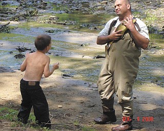 Fish around with your kids: Bob Grable, head of Scenic Rivers of Ohio with the Ohio Department of Natural Resources, shares a moment with a young boy attending a past Explore the Outdoors With Your Family event at Beaver Creek State Park, 10201 Echo Dell Road, East Liverpool. This year’s event will be from 11 a.m. to 4 p.m. Saturday, sponsored by Columbiana County Conservation Partners, the park and others. An array of activities for parents and children will be offered, including a helicopter landing, macro-invertebrate sampling, an artesian blacksmith, a rain-barrel display, fish electro-shocking, making pine cone feeders, face-painting, designing your own T-shirts, bow shooting, grain grinding, touch-and-feel boxes, drumming, emergency vehicles to explore and a hike. For information contact Tom Butch at 330-337-8444.

