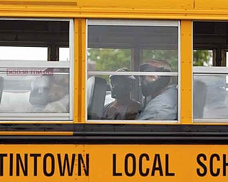 Wearing protective gear, area bus drivers sit in the bus, during a mock crisis drill at Austintown Fitch High School, waiting to witness what would happen if an intruder got onto the vehicle.