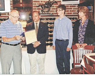 Service recognition: Paul Paris, left, Struthers Rotary charter member and Struthers School Foundation chairman, presents Bryan Higgins, past president, with the Paul Harris Fellow for his service this past year as Higgins’ son, Bryan, and wife, Michelle, look on. The presentation was made in July during the club’s annual Presidents Dinner at Springfield Grille in Boardman.
