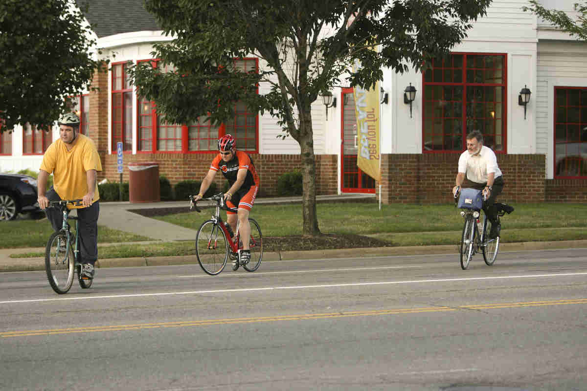 ROBERT K. YOSAY | THE VINDICATOR..Leaving Downtown Poland Todd Carl and Frank go for the turn lane -  to start the 7 mile trek to work in Youngstown..Ride to work with Franko...Frank Krygowski-- White shirt -- Carl Frost - Orange and Black - Todd Franko in Orange -30-