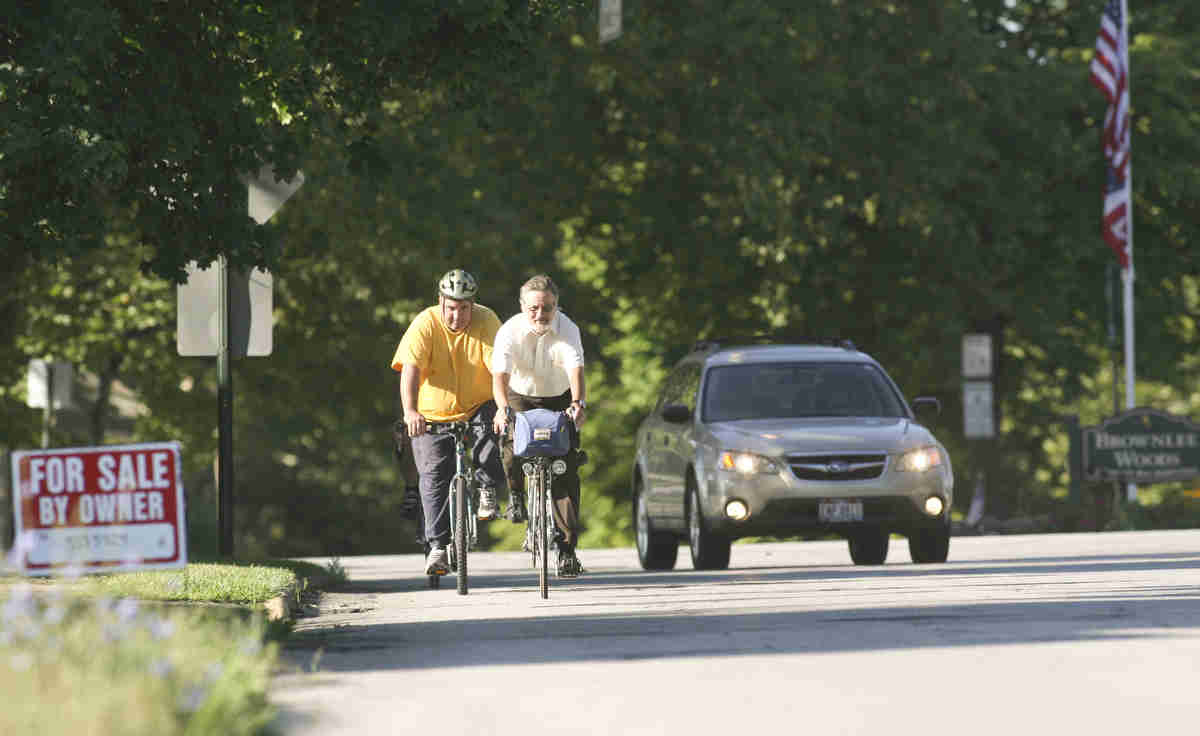 ROBERT K. YOSAY | THE VINDICATOR..A passing car gives the riders room as they head east on Sheridan (Midlothian is behind them)..Ride to work with Franko...Frank Krygowski-- White shirt -- Carl Frost - Orange and Black - Todd Franko in Orange -30-