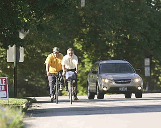 ROBERT K. YOSAY | THE VINDICATOR..A passing car gives the riders room as they head east on Sheridan (Midlothian is behind them)..Ride to work with Franko...Frank Krygowski-- White shirt -- Carl Frost - Orange and Black - Todd Franko in Orange -30-