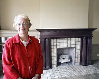 Constance Shaffer, retired executive director of the Youngstown YWCA, stands in front of a fireplace in the lobby of the YW building.
