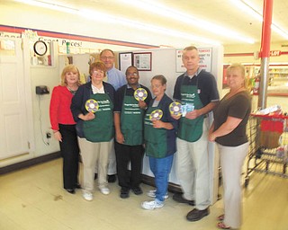 Thanks for remembering: Helen Paes, left, of the Alzheimer’s Association of Greater East Ohio Area Chapter, and Sam Morroco, second row, and Kimberly Tonkovich, right, both of Banker’s Life and Casualty, recently stopped by the Lincoln Knolls Plaza’s Save-A-Lot store to thank the staff, including, in aprons, from left, Mary Ellen Filer, Les Hawkins, Judy Smeltzer and Rob Yurko, store manager, for their efforts during the ninth annual Forget-Me-Not Days. During the two-day event, May 13-14, Bankers employees and volunteers collected donations and handed out forget-me-not seeds, and cashiers at eight Save-A-Lot stores and IGA Supermarkets owned by Henry Nemenz, and two Save-A-Lots owner by Richard Stacey, sold paper forget-me-nots. More than $5,000 was presented to the local Alzheimer’s chapter. The national Association operates a toll-free nationwide helpline for families and caregivers, 24 hours a day, seven days a week at 1-800-272-3900.
