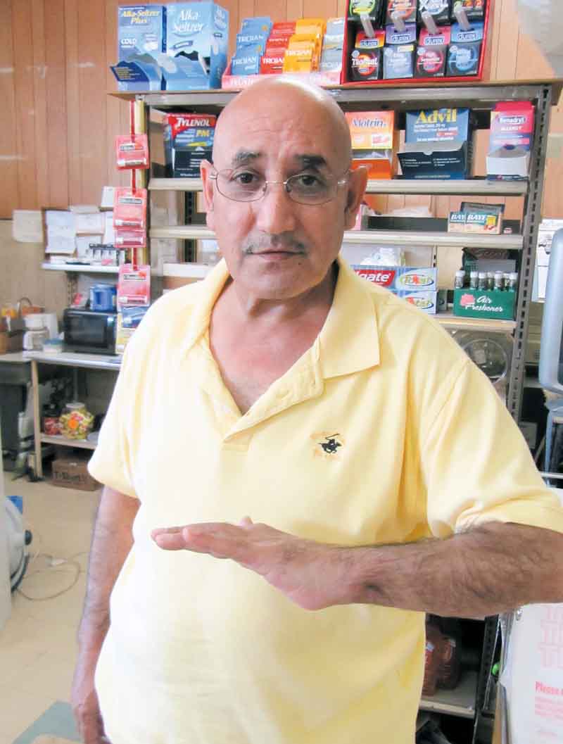 Mohammad Darwish, owner of the NorthEnd Market, shows the injury he suffered to his left arm and hand during a robbery at his store March 12. A robber fired a shot at Darwish that hit him in the hand and then entered his stomach. The man took money and fled on foot. The suspect, Jacquavis K. Williams, turned himself in to police Thursday.