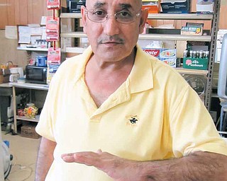 Mohammad Darwish, owner of the NorthEnd Market, shows the injury he suffered to his left arm and hand during a robbery at his store March 12. A robber fired a shot at Darwish that hit him in the hand and then entered his stomach. The man took money and fled on foot. The suspect, Jacquavis K. Williams, turned himself in to police Thursday.