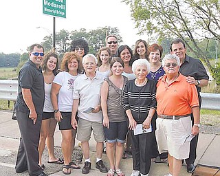 Members of the Modarelli family stand in front of the new bridge sign after the ribbon-cutting ceremony and dedication of the Dominic “Dee Dee” Modarelli Memorial Bridge in Youngstown. The event also marked the beginning of the Brier Hill Italian Festival.