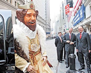 FILE - In this May 18, 2006 photo, Burger King CEO John W. Chidsey, background center, watches as"The King" mascot of Burger King Corp., arrives at the New York Stock Exchange in New York.  Burger King's spooky "The King" mascot is retiring so the struggling burger chain can refocus its marketing to reach new customers. The mascot has been around for years, but recently has become a more prevalent and somewhat creepy presence in ads.   The fast food chain, which has suffered declining sales, will roll out a new advertising campaign this weekend sans "The King" that will focus on its burgers.    (AP Photo/Richard Drew)