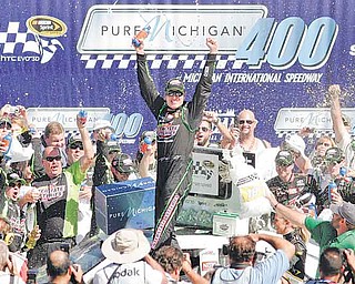 Kyle Busch celebrates his victory in the NASCAR Sprint Cup Series auto race at Michigan International Speedway in Brooklyn, Mich., on Sunday.
