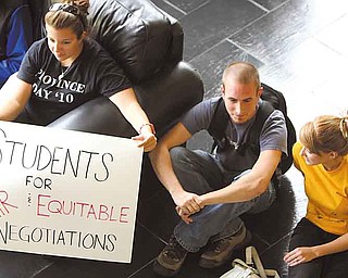 Julie Sabo of Mentor, left, sits quietly with Jim Davis of Columbiana and Christi Walton of Youngstown during a peaceful protest Monday at Youngstown State University.  These three seniors, and other students, had a sit-in at Tod Hall and then walked to Williamson Hall, where contract negotiations with faculty are ongoing. The students are worried about financial aid disbursements, as well as the start of classes.