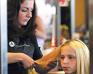 Rebekah Eastham of Wellsville starts cutting Britney Hallett’s hair. The 16-year-old student from Youngstown was one of 30 kids who took part in the Angels For Kids’ back-to-school make over at Casal’s Aveda Institute, Austintown. 