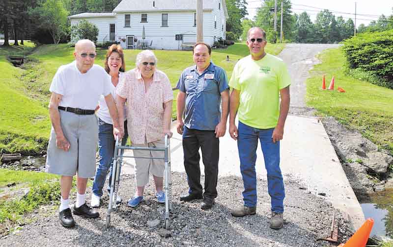 Haynie family members, from left, Walt, Grace and Betty and Jardine Building employees Bob Kolat and Eugene Macek stand in front of a damaged bridge that needs to be repaired. The bridge is the only access the Haynie family has to Niles-Vienna Road from their homes.