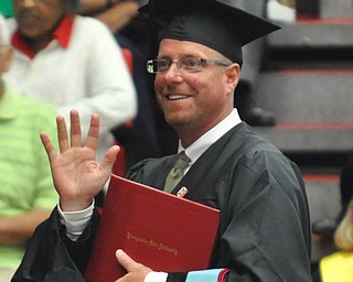 Jason R. Mays waves at his family as he approaches the stage to receive his Masters of Educational Administration degree at the 2011 YSU summer commencement...Photo By: Lindsay Y McCall | The Vindicator