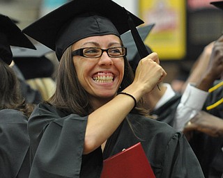 A recent YSU graduate moves her tassle to signify her graduation while smiling at her parents in the crowd...Photo By: Lindsay Y McCall | The Vindicator