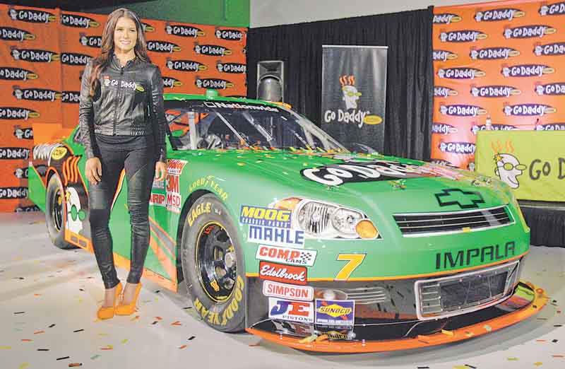 Driver Danica Patrick displays the car that she will drive full-time in the NASCAR Nationwide Series circuit and select Sprint Cup races during an auto racing news conference Thursday, Aug 25, 2011, in Scottsdale, Ariz.  After months of skirting speculation, Patrick announced Thursday that she's leaving IndyCar in 2012 to run a full Nationwide schedule with JR Motorsports and up to 10 Sprint Cup races for Stewart-Haas Racing.  (AP Photo/Paul Connors)