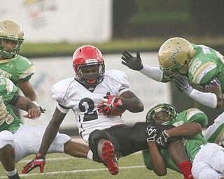 ROBERT K. YOSAY | THE VINDICATOR..BRINGIN HIM DOWN - Ursulines #25 Tramain Thigpen, #24 Jermaine Williams #1 Anthony Davis and by the leg #6 Shannon Hightower bring down #24 Red Lions Wendell Smallwood - -- Youngstown Ursuline vs Red Lion Christian Academy at Stambaugh Stadium Friday night. .----..... -30-