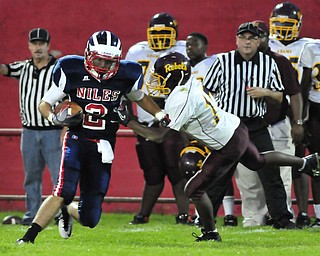 Niles receiver #2Gage McCracken runs upfield after making a catch while John Adams #17 Reginald Thomas tries to tackle him.