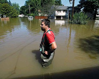 Gino Borova stands in the driveway of his house in Pompton Lakes, N.J., where the Ramapo River crested in the aftermath of Hurricane Irene. Borova has lived in the house for six months and has seen two floods damage his property.