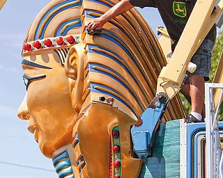 R. Robert Strain with Bates Brothers Amusement polishes the head of Pharoah’s Fury at the Canfield Fairgrounds on Tuesday. The 165th Canfield Fair opens today.