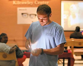 Galen Hayek, a Youngstown State University senior majoring in chemistry, knocks together two shot-put balls, one rusted and one covered in aluminum foil, to make sparks and a loud pop. YSU’s Office of Associate Degree and Tech Prep Programs sponsored the second Geek Fest on Tuesday in Kilcawley Center’s Chestnut Room.