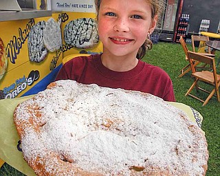 Hannah Heikkinen, 7, of Boardman, enjoys an elephant ear coated in powered sugar during the first day of the Canfield Fair.